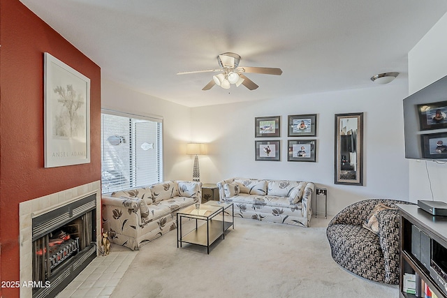 carpeted living room featuring a ceiling fan and a tile fireplace