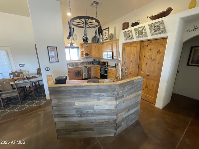 kitchen with sink, stainless steel appliances, kitchen peninsula, and a high ceiling