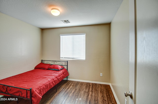 bedroom with dark wood-type flooring and a textured ceiling