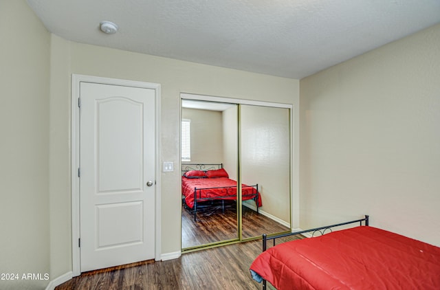 bedroom featuring hardwood / wood-style floors, a closet, and a textured ceiling