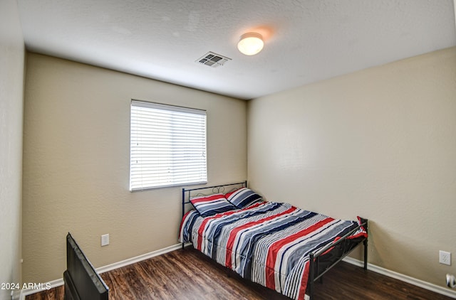 bedroom with dark wood-type flooring