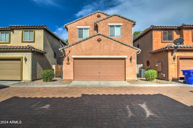 mediterranean / spanish-style house featuring a garage and central AC unit