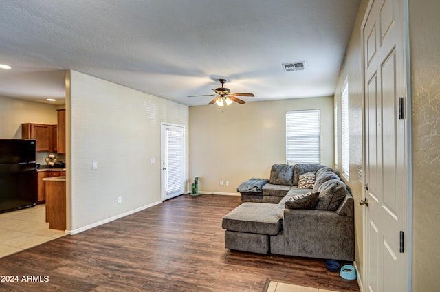 living room with hardwood / wood-style floors, a textured ceiling, and ceiling fan