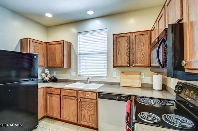 kitchen with sink, light tile patterned floors, and black appliances