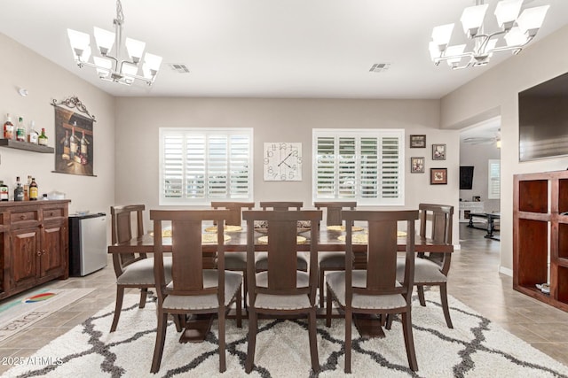 dining space featuring ceiling fan with notable chandelier