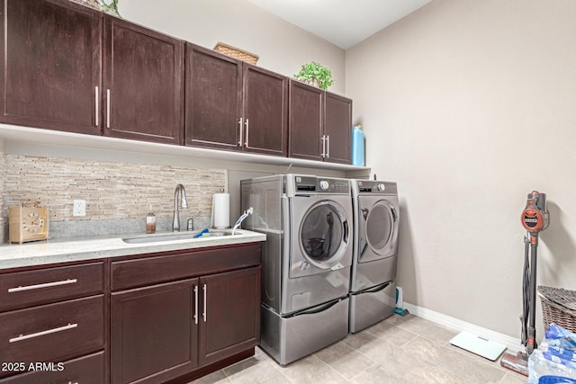 clothes washing area with cabinets, sink, and washing machine and dryer