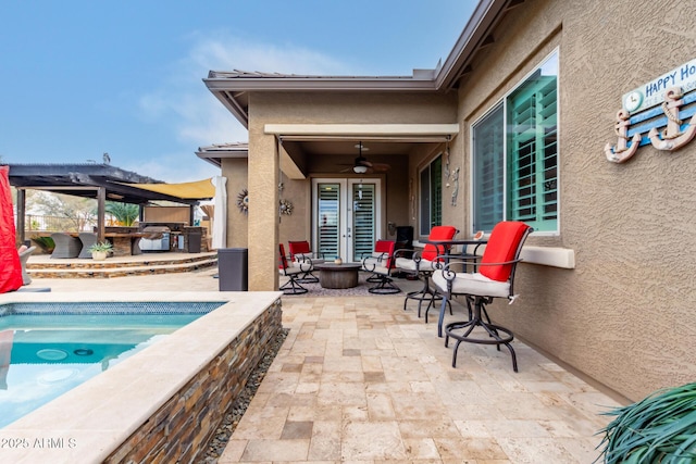 view of patio / terrace with a swimming pool, ceiling fan, and exterior kitchen