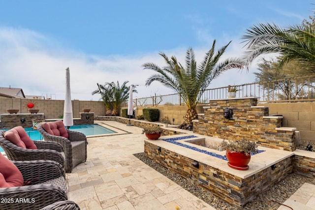 view of patio featuring a fenced in pool and an outdoor fire pit