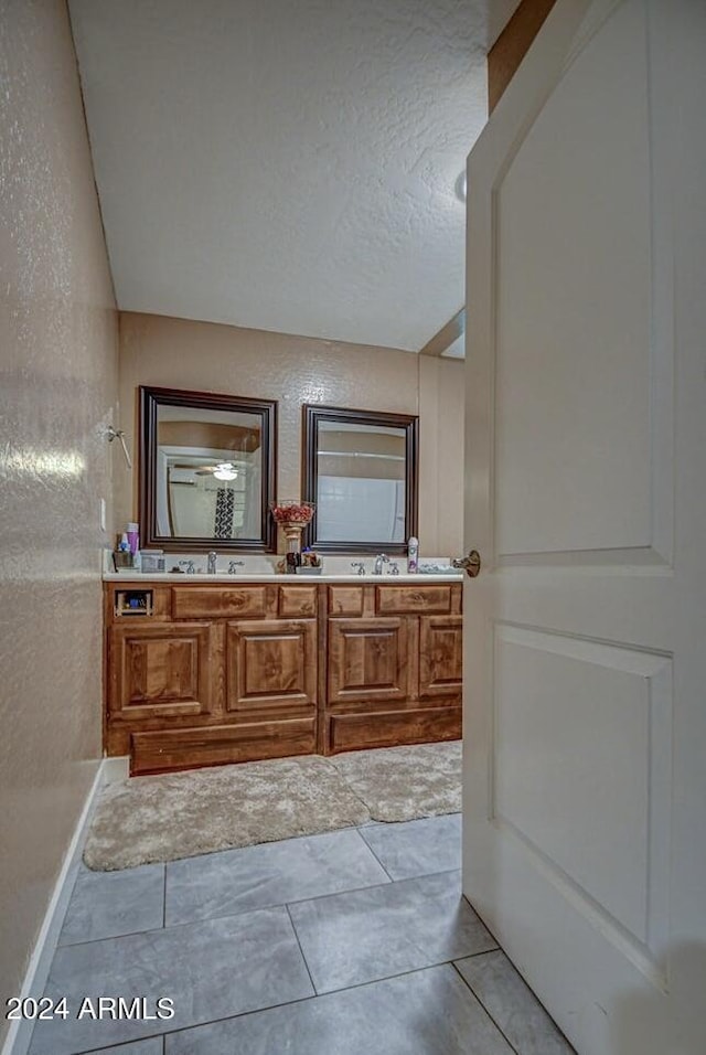 bathroom featuring tile patterned flooring, vanity, and vaulted ceiling