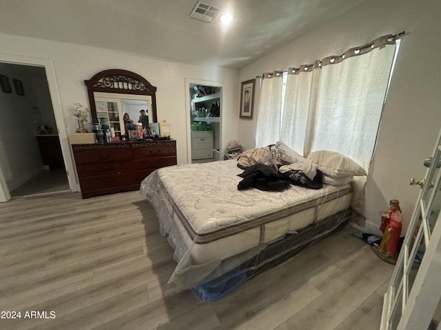 bedroom with light hardwood / wood-style floors and vaulted ceiling