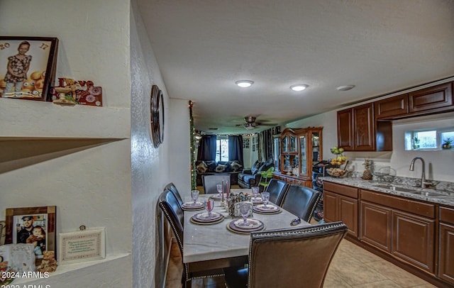 tiled dining space with ceiling fan, plenty of natural light, a textured ceiling, and sink