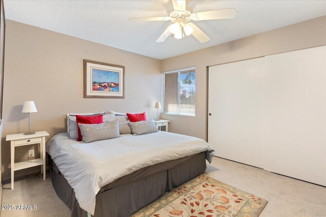 bedroom with a closet, light colored carpet, and a ceiling fan