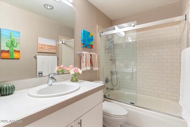 full bathroom with toilet, vanity, and shower / bath combination with glass door