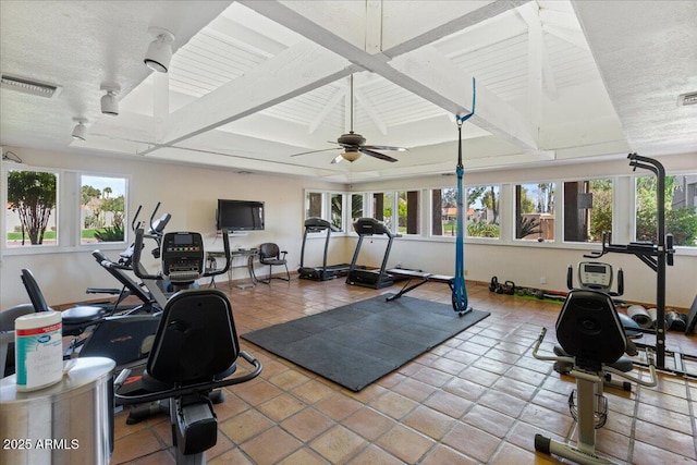 exercise area with visible vents, baseboards, ceiling fan, and vaulted ceiling