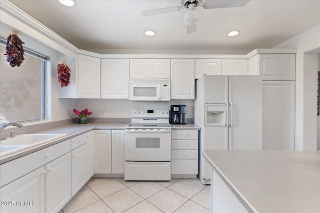 kitchen with light tile patterned flooring, white appliances, white cabinetry, and a sink