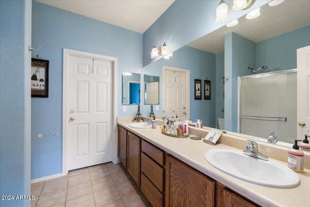 full bathroom with a stall shower, tile patterned flooring, a sink, and double vanity