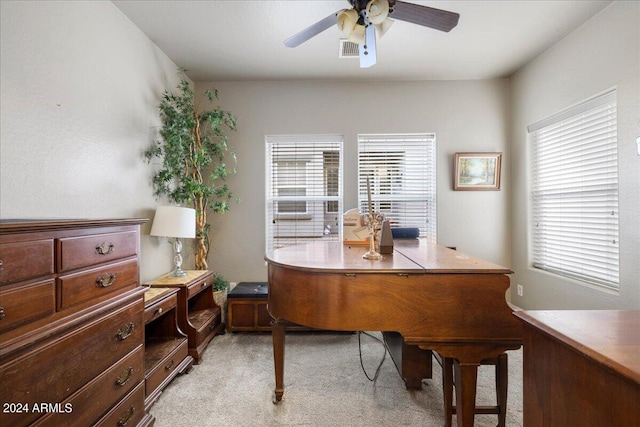 home office with a ceiling fan, visible vents, and light carpet