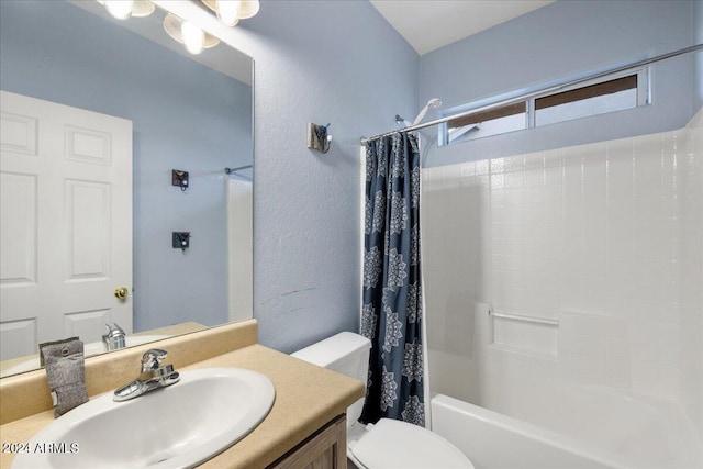 full bathroom with shower / bath combination with curtain, a textured wall, vanity, and toilet