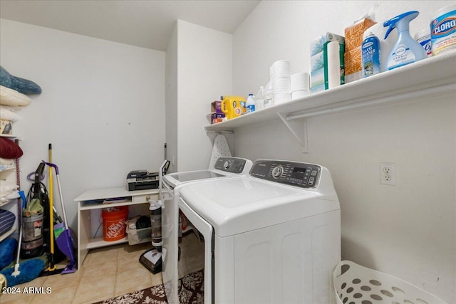 clothes washing area with laundry area, washing machine and dryer, and light tile patterned flooring