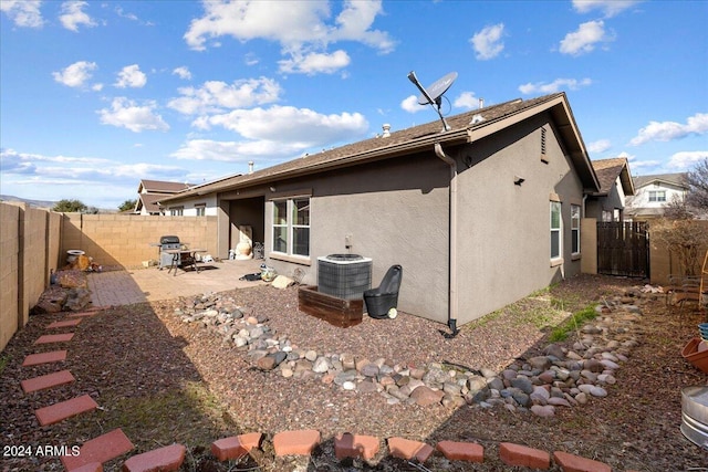 rear view of property with central air condition unit, a fenced backyard, a patio, and stucco siding