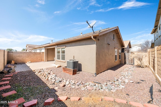 back of house featuring central air condition unit, a fenced backyard, a patio, and stucco siding