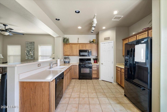 kitchen featuring a sink, visible vents, light countertops, black appliances, and brown cabinetry