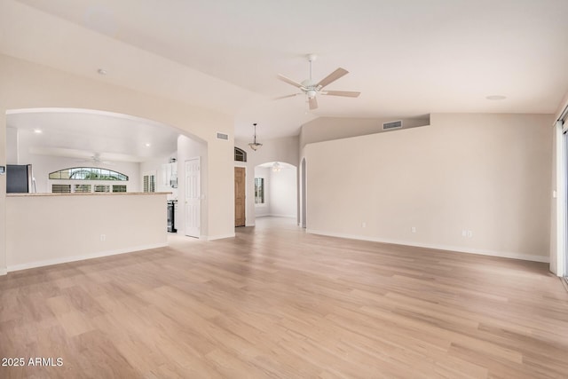 3582 N 160th Ave, Goodyear, AZ 85395 - unfurnished living room with a ceiling fan, light wood-style floors, arched walkways, lofted ceiling, and baseboards