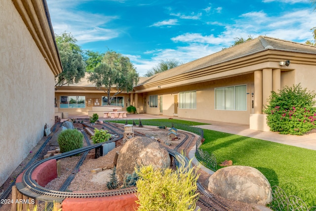 rear view of property featuring a lawn