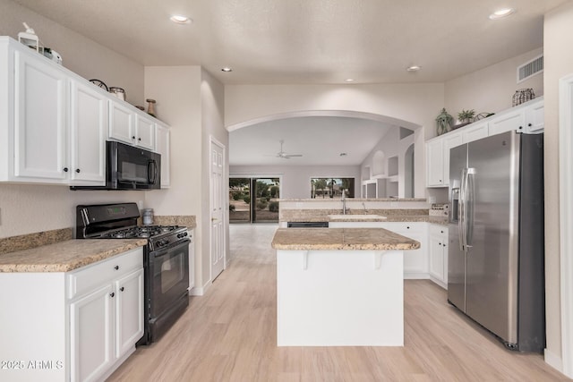 3582 N 160th Ave, Goodyear, AZ 85395 - kitchen with black appliances, a sink, arched walkways, light wood finished floors, and recessed lighting