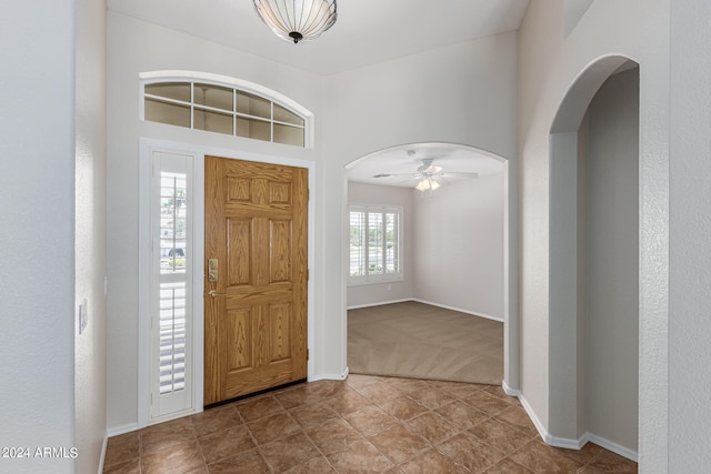 carpeted entrance foyer featuring ceiling fan