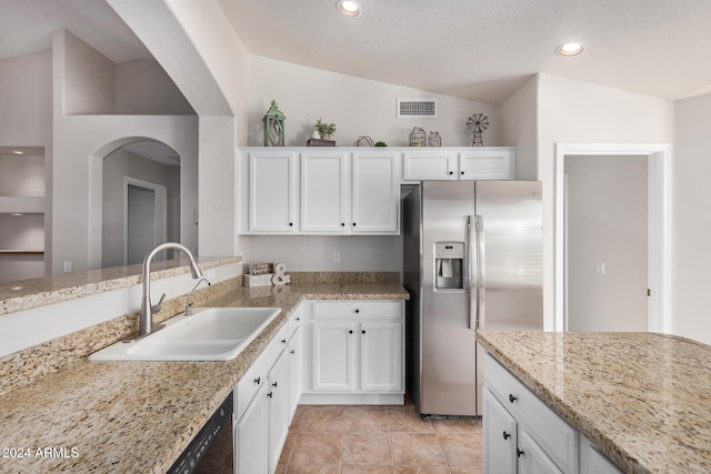 kitchen with sink, vaulted ceiling, stainless steel fridge with ice dispenser, light stone counters, and white cabinetry