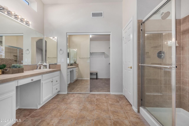 bathroom featuring tile patterned floors, vanity, and a shower with shower door