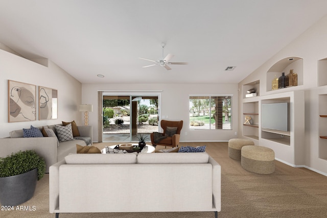 carpeted living room with lofted ceiling, ceiling fan, and built in features