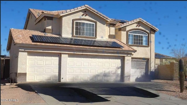 view of front of home with solar panels, an attached garage, and stucco siding