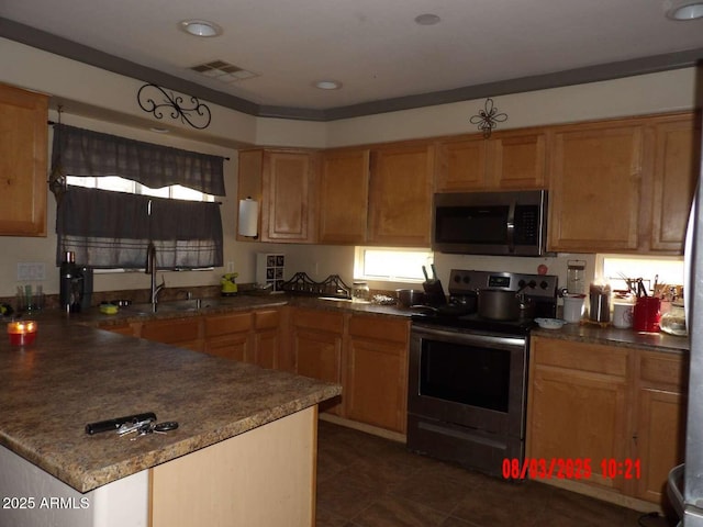 kitchen with a sink, a peninsula, visible vents, and stainless steel appliances