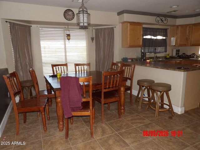 dining space featuring dark tile patterned floors and baseboards