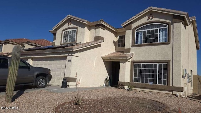 view of front of house with stucco siding, a tile roof, and a garage