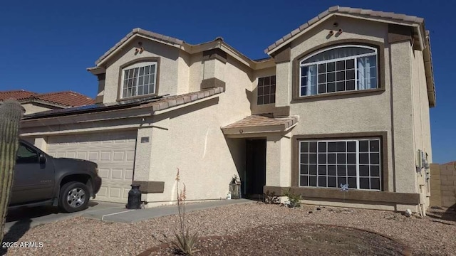 view of front of property with a tile roof, a garage, and stucco siding