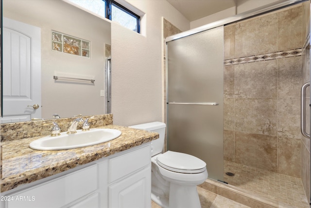 bathroom with tile patterned flooring, vanity, toilet, and a shower with door