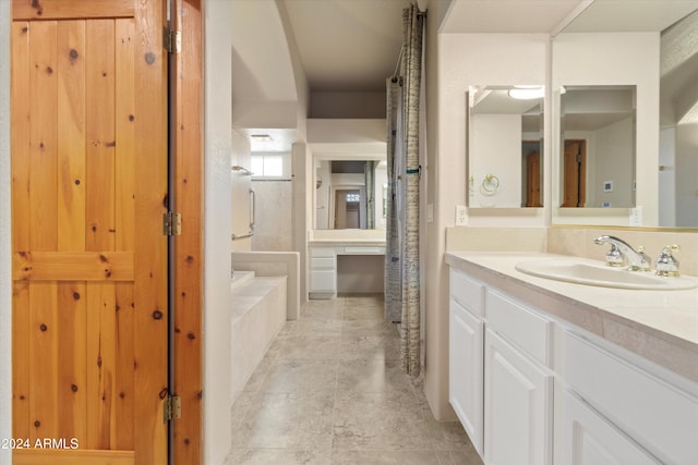 bathroom featuring vanity and a relaxing tiled tub