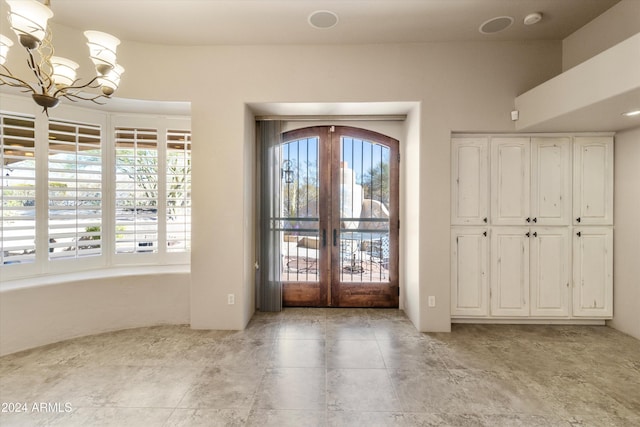 foyer with french doors and an inviting chandelier