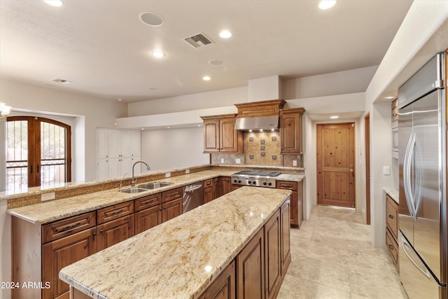 kitchen featuring sink, french doors, kitchen peninsula, exhaust hood, and appliances with stainless steel finishes