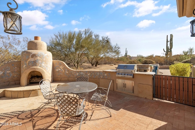 view of patio / terrace featuring grilling area, area for grilling, and an outdoor fireplace