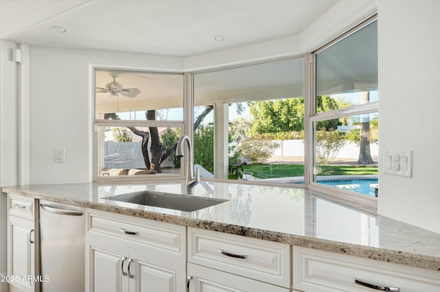 kitchen with white cabinetry, light stone countertops, sink, and plenty of natural light