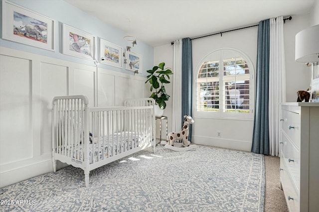 bedroom featuring a crib and carpet flooring