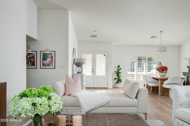 living room with french doors and light hardwood / wood-style floors