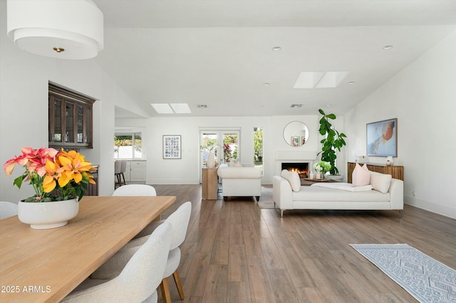 living room with hardwood / wood-style flooring and lofted ceiling with skylight