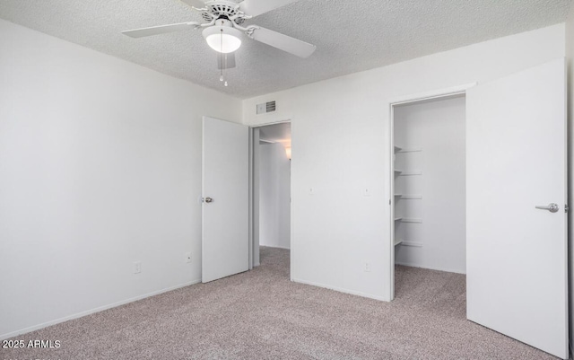 3511 E Baseline Rd Unit 1235, Phoenix, AZ 85042 - unfurnished bedroom with carpet, a textured ceiling, a spacious closet, a closet, and ceiling fan