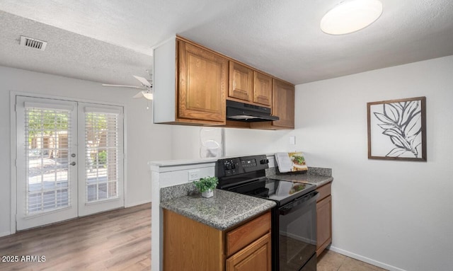 3511 E Baseline Rd Unit 1235, Phoenix, AZ 85042 - kitchen featuring black electric range oven, under cabinet range hood, brown cabinetry, a ceiling fan, and a textured ceiling