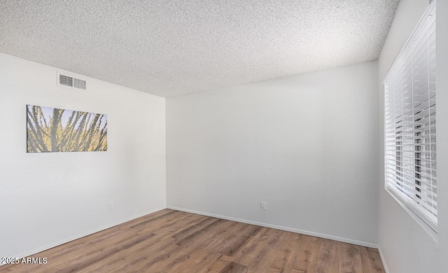 3511 E Baseline Rd Unit 1235, Phoenix, AZ 85042 - empty room with wood finished floors, a textured ceiling, and baseboards